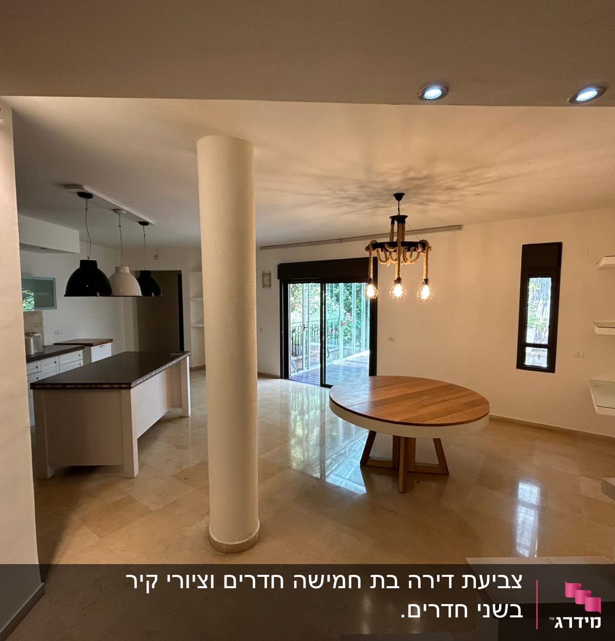 מטבח עם שולחן עגול ומנורות תלויות